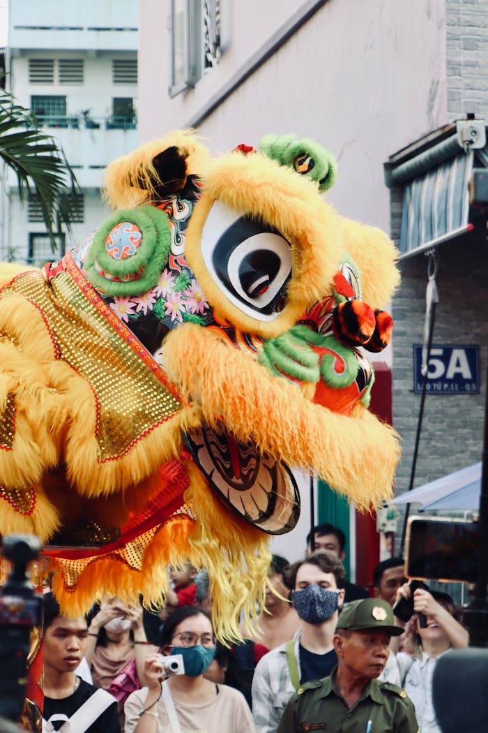 Colorful lion dance amidst a lively street crowd during a cultural festival.